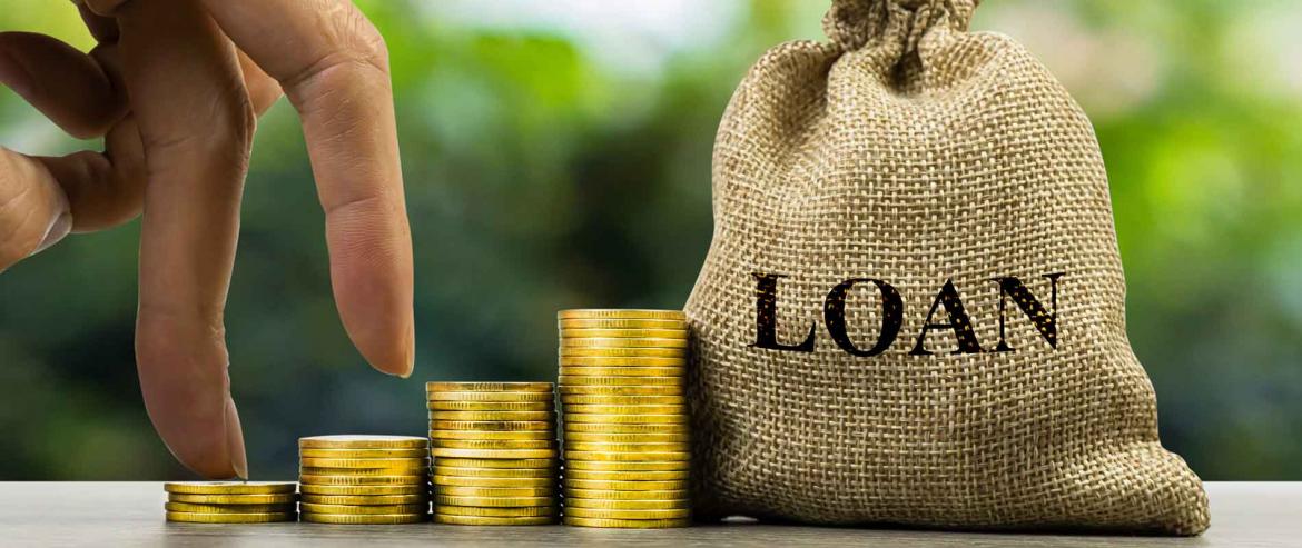 Growing stacks of coins beside a loan money bag
